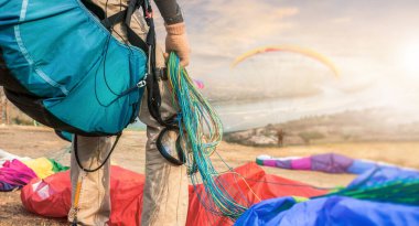 Paraglider on the ground. paragliders with full flight equipment look on soaring another paragliders at nong khai thailand, Landscape from Beautiful View Mekong River. clipart