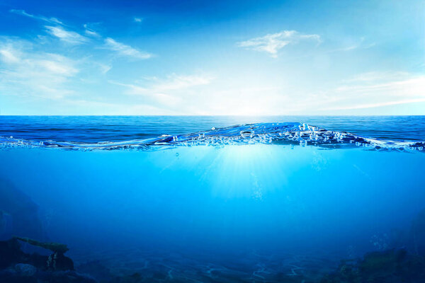 Волны и пузыри синей воды. Белые облака на голубом небе над спокойным морем с солнечным светом, спокойная морская гармония спокойной водной поверхности. Солнечное небо и спокойный голубой океан.