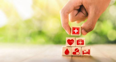 Hand arranged wooden blocks with icons of medical health. health insurance for your health concept. Healthcare medical business, medical technology equipment icon, health care protection concept.