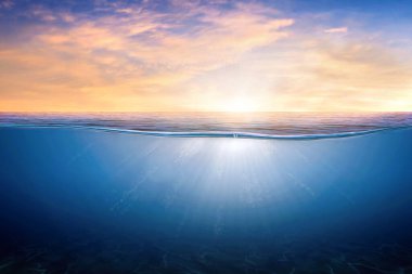 Suyun altındaki mavi dalgalar ve kabarcıklar. Durgun deniz üzerinde turuncu ve altın gün batımı gökyüzü güneş ışığı yansıması, sakin su yüzeyinin sakin deniz uyumu. Gün batımı gökyüzü ve sakin mavi okyanus.