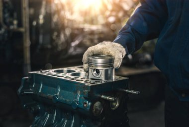 Yedek araba parçaları. İçten yanmalı motorun silindir başı. Tamircinin ellerine yakın çekim. Ürün kontrolü. Yoğunlaştırıcı kurulumu. Kurulum için hazırlık. Onarım ve bakım.