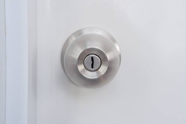 Beyaz bir kapıya monte edilmiş gümüş bir kapı tokmağının yakın çekimi.