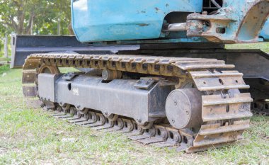 Sürüngen kepçe yükleyicisi yan görüş alanında. Çimlerin üzerinde