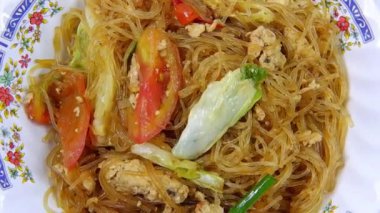 Tayland sokak yemeklerini kapat, yumurta, domates ve sebzelerle karıştırılmış vermicelli beyaz arka planda.