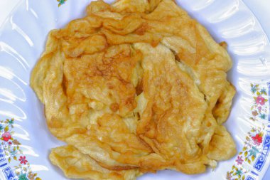 Beyaz arka planda beyaz tabakta kızarmış omlet Tayland 'da yerel yemek.