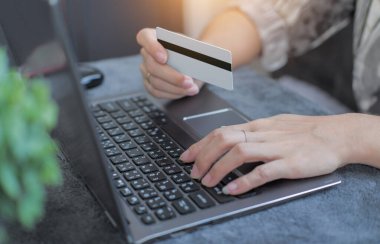 Ekommerce mağazasında bilgisayar alışverişinde kredi kartı fatura bilgilerini kullanan bir kadın. konsept: çevrimiçi ödeme, erişilebilir internet para aktarımı