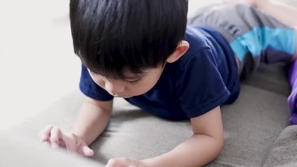 Chłopiec Szczęśliwie Leży Kanapie Bawiąc Się Telefonem — Wideo stockowe