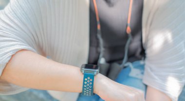 Kadın kollarını kaldırıp, bilgi işlemek için uygun saate bakıyor..