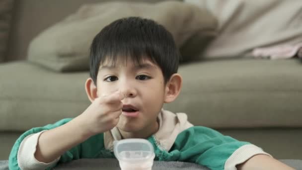 一个男孩很高兴用勺子把酸奶捞上来 — 图库视频影像