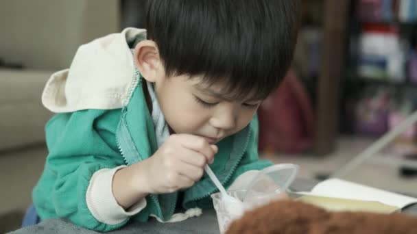Мальчик Радостью Использует Ложку Достать Йогурт — стоковое видео