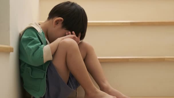 Ledsen Asiatisk Pojke Sätter Sig Med Huvudet Trappan — Stockvideo