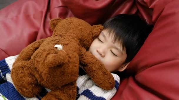 Хлопчик Спить Обіймає Плюшевого Ведмедя Червоному Матраці — стокове відео