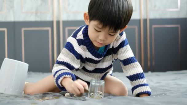 Asiatisk Pojke Räknar Gärna Mynt För Att Spara Pengar — Stockvideo