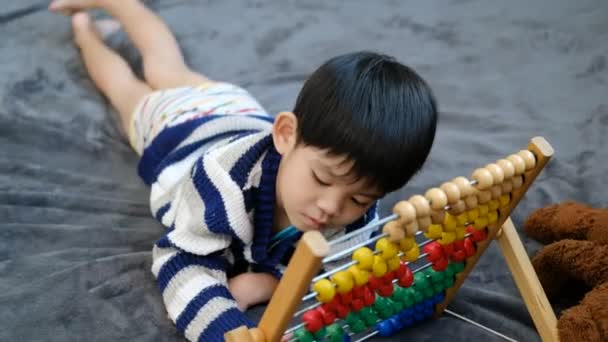 Asiatisk Pojke Leker Med Leksaker Sängen — Stockvideo