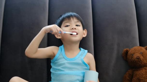 Asiatisk Pojke Borsta Tänderna Vardagsrummet — Stockvideo