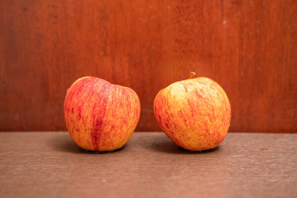 Orange-red apples on a wood grain background