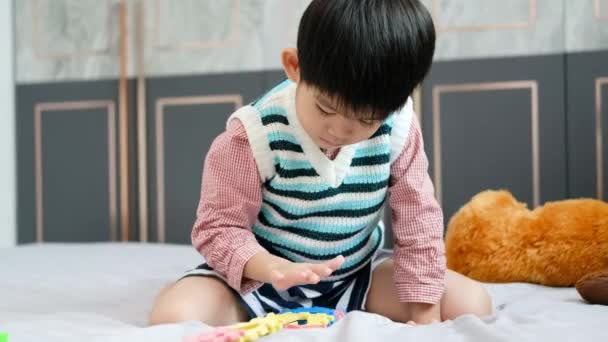 Asian Boy Playing Jigsaw Puzzles Bed Joyfully — Stock Video