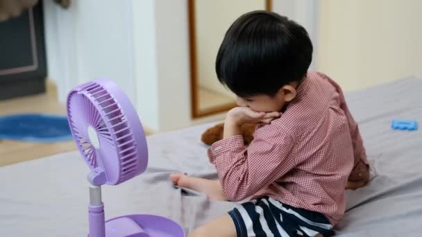 Azji Chłopiec Leżąc Materacu Gorący Dzień Zabawy Przenośnym Wentylatorem Szczęśliwie — Wideo stockowe