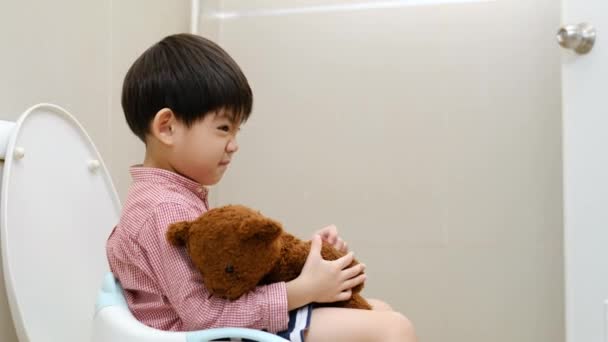 Asian Boy Sitting Toilet Bowl Hand Holding Teddy Bear — Stock Video