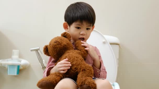 Asijský Chlapec Sedí Záchodové Míse Ruce Drží Medvídka — Stock video