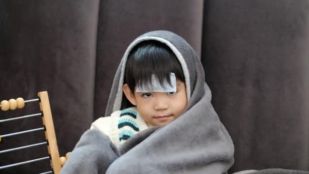 亚洲男孩病了躺在床上 额头上长了一块发热斑斑 由于感冒 他用毯子盖住了自己 — 图库视频影像