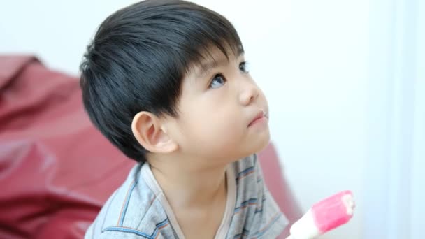 Азиатский Мальчик Ест Вкусное Мороженое Кресле — стоковое видео