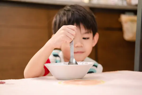 The face of an Asian child eating rice