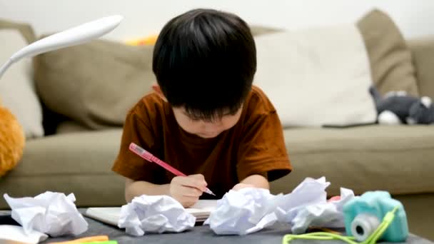 アジアの少年がテーブルの上に描いて テーブルの上に紙の部分がありました — ストック動画