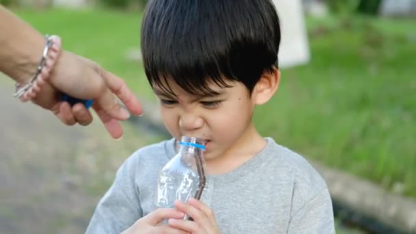 Asiático Niño Bebiendo Agua Una Botella Sostenida Por Madre — Vídeo de stock