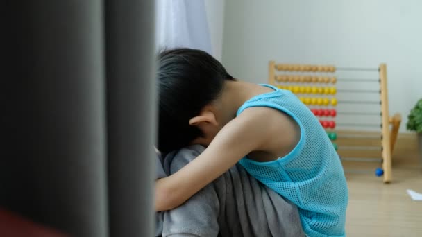 Trauriger Asiatischer Junge Sitzt Mit Gesenktem Kopf Vor Der Tür — Stockvideo