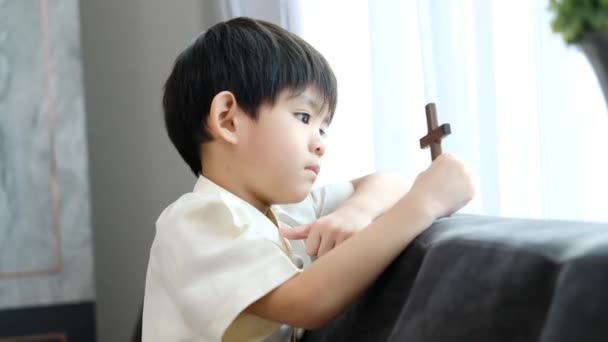 Kleine Aziatische Jongen Bidden Met Het Vasthouden Van Het Kruis — Stockvideo