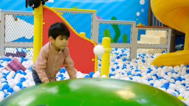 Kleiner Asiatischer Junge Blickt Auf Einen Schwimmenden Ball Zwischen Vielen — Stockvideo