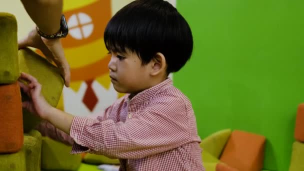 Ένα Μικρό Ασιατικό Αγόρι Παίζει Ένα Μεγάλο Τετράγωνο Παζλ — Αρχείο Βίντεο
