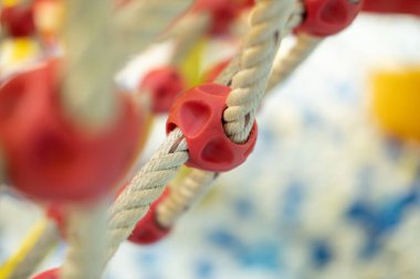 Bir oyun parkında yerde küçük toplar olan bir tırmanma ağına yakın plan..