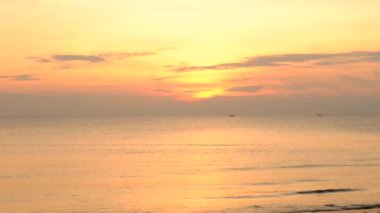 Gün batımında deniz sınırında manzara Denizin ortasında yüzen bir gemi var.