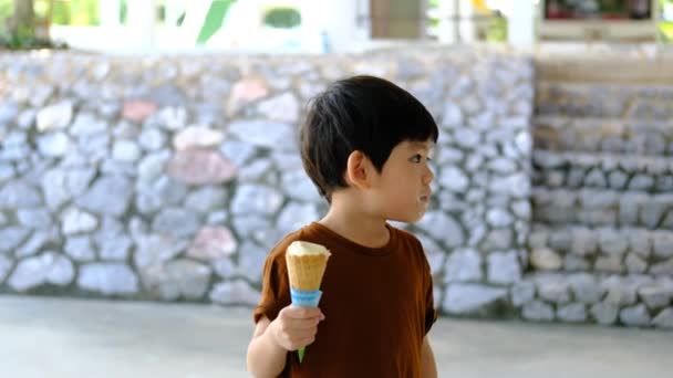Little Asian Boy Eating Delicious White Chocolate Ice Cream — Stock Video