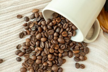 Kahve fincanından yayılan kahve çekirdekleri.