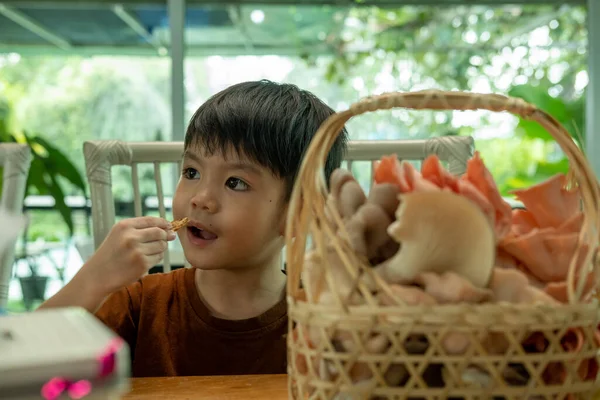 Asian boy eating processed food made from mushrooms