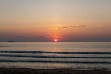 Alacakaranlık ışıklarıyla deniz kıyısında gün doğumu