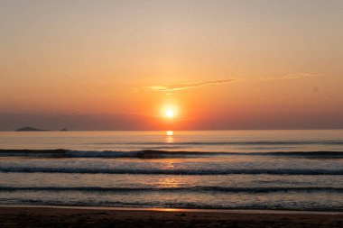 Alacakaranlık ışıklarıyla deniz kıyısında gün doğumu