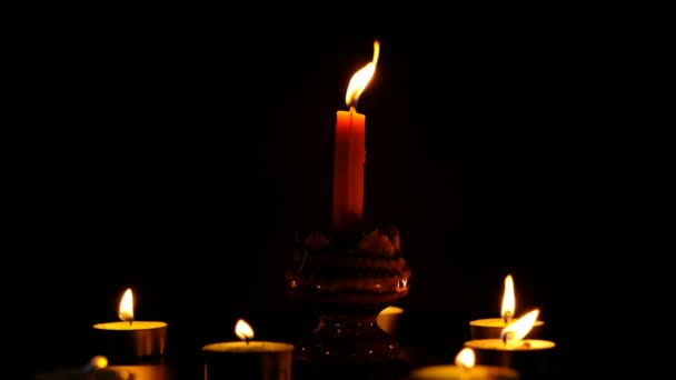 许多蜡烛在黑色的背景下闪耀 在黑暗的桌子记忆中燃烧着蜡烛 — 图库视频影像