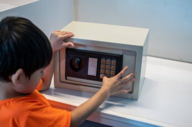 Küçük Asyalı çocuk evde kasa açıyor.