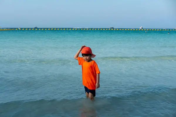 Little Asian boy playing in the sea at the sea beach