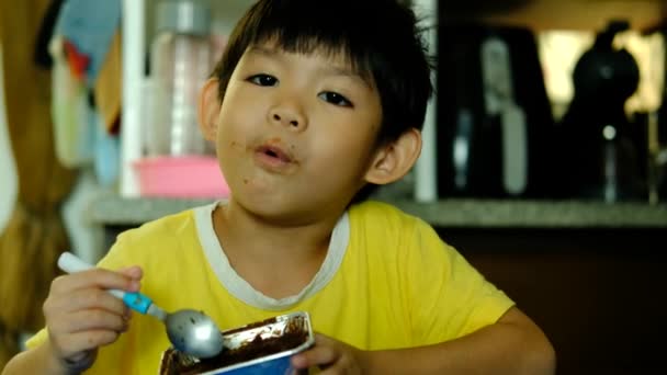 Little Asian Boy Sitting Eating Chocolate Cake — Stock Video