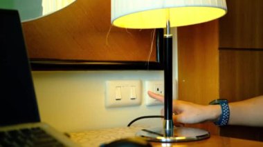A woman's hand is pulling an electrical plug to turn off a switch. to save energy