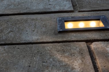 Tuğla duvarda, tavan arası süslemesi olarak açık hava lambası var.