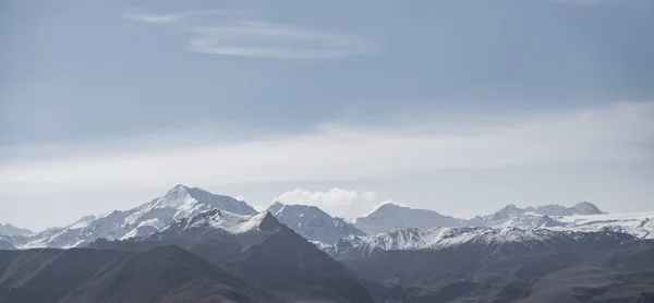 山の岩の範囲 丘や雪と氷河のピークのパノラマビュー 曇りの空とモノクロームの風景 — ストック写真