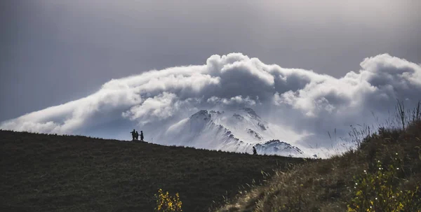 Toeristen Bergen Een Heuvel Verte Tegen Achtergrond Van Een Berg — Stockfoto