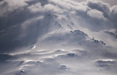 Elbrus Dağı 'nda dağ atmosferi. Kafkasya' nın dağlık bölgelerinde, güneşin altında, bulutlu havada parlayan buzullar.