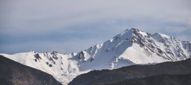 Karlı ve buzullu dağ zirveleri olan bir dağ manzarası Kafkasya 'da bulutlu bir sonbahar günü.